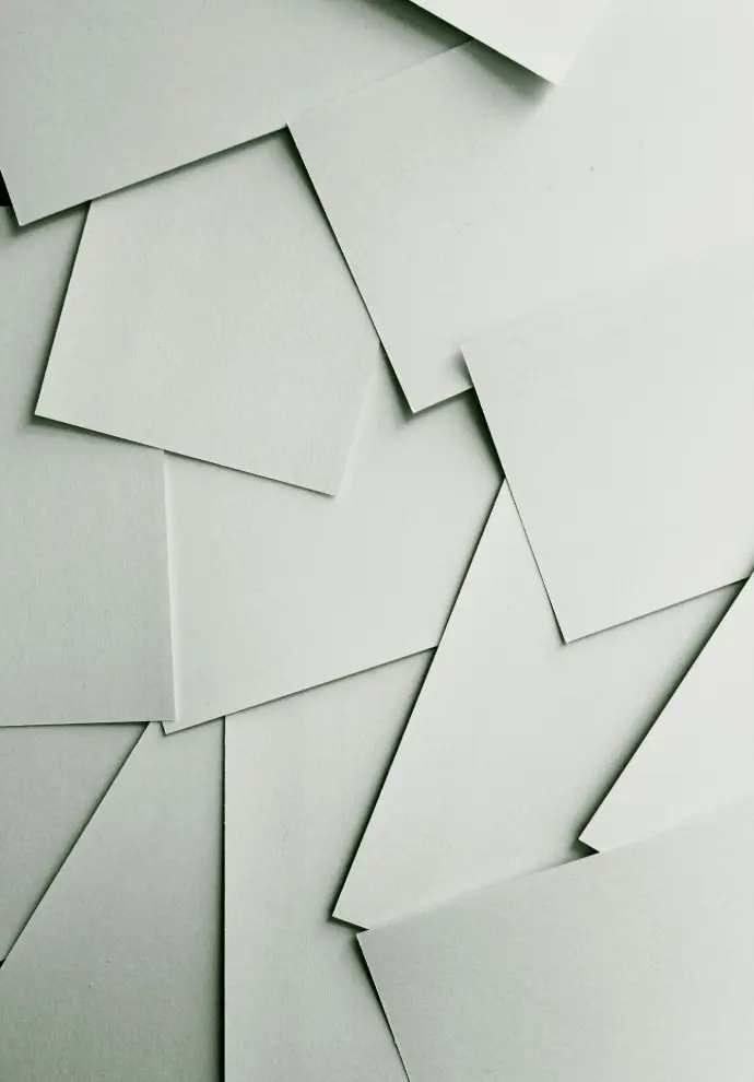 Scattered sheets of white paper covering the entire frame